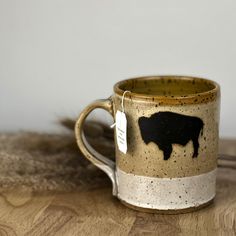 a coffee cup with a black cow on it