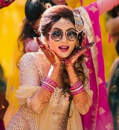 a woman with henna on her face and hands in front of her face,