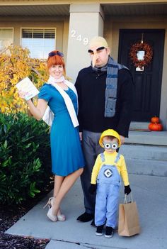 a man and woman standing next to each other in front of a house with a costume on