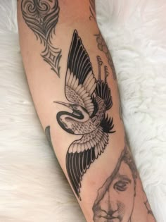 a woman's leg with tattoos on it and a bird flying over her head