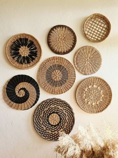 several woven baskets are hanging on the wall