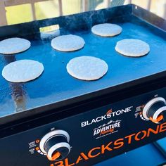 an electric grill with six pancakes cooking on it's burners and the words blackstone above them