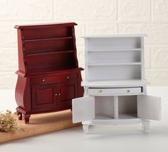 two miniature white and red furniture pieces on a wooden table next to a piece of wood