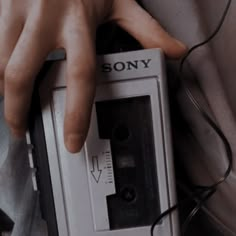 a person holding an old fashioned radio in their left hand with the word sony on it