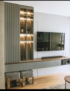 an entertainment center with built - in shelves and lights on the wall, along with two chairs