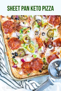 a sheet pan pizza with pepperoni, olives, and cheese on it next to a spatula