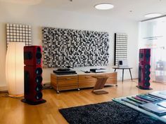 a living room filled with furniture and speakers on top of hard wood floored floors