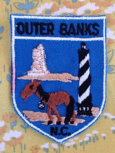 the outer banks logo is shown on a yellow and blue floraled shirt with an image of a horse