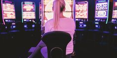 a woman sitting in front of slot machines