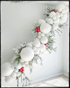 a christmas garland made out of white balls and greenery