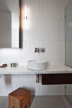 a bathroom with a sink, mirror and stool