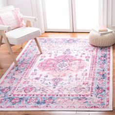 a pink and blue area rug in front of a white chair with pillows on it