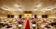 a banquet hall with tables, chairs and chandeliers set up for an event