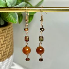 Handmade beaded wire earrings - Warm golden brown boho dangle earrings  Up your style with these gorgeous earrings! Featuring beautiful warm brown multicolor beads with golden toned wire accents, these beauties are full of personality and earthy elegance. Perfect for any occasion, they add the right pop of color and sparkle. Lightweight, eye-catching, and unique--these earrings are a must-have for any jewelry lover and also make a lovely gift!  Care Instructions: To keep your earrings looking their best: - Avoid Water and Chemicals: Remove earrings before swimming, showering, or bathing - Store Properly: Keep them in a dry, cool place, ideally in a soft pouch or jewelry box - Gentle Cleaning: Wipe gently with a soft, lint-free cloth after each wear to remove any oils or residues -Handle wi Beaded Wire Earrings, Earrings Handmade Beaded, Brown Earrings, Brown Jewelry, Warm Brown, Wire Earrings, Gorgeous Earrings, Jewelry Lover, Golden Brown