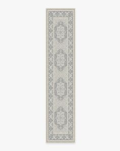 a white and gray rug with an ornate border