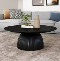 This round coffee table brings sleek style and warm wood to center stage. It's made from engineered wood. This table features a smooth, hourglass-style silhouette – rounding out your space while offering visual dimension. Stylish and versatile, it complements contemporary and industrial décor styles alike. Place it in front of your loveseat or sofa, and use it to rest books, beverages, and display items. Then, sit back and watch as it ties your s Round Black Coffee Table, Round Coffee Table Styling, Black Coffee Table, Room Sofa Design, Coffee Table Black, Round Wood Coffee Table, Solid Coffee Table, Drum Table