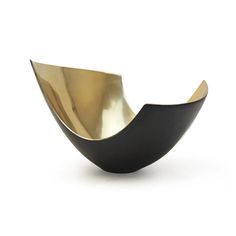 a black and gold bowl sitting on top of a white table