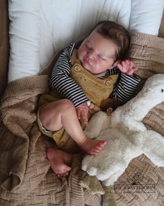 a baby sleeping next to a stuffed animal