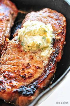 two steaks with butter on top in a skillet