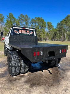 the back end of a truck parked on dirt