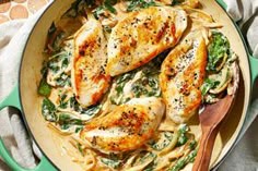 chicken with spinach and noodles in a green skillet