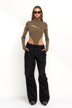 Introducing our new Ari Parachute Pants featuring a cargo wide leg pant design. These parachute cargo pants come in the colors black, beige, and cream. The Ari Parachute Pants come with cargo like pockets on both legs as well as normal pockets along the hips. These wide leg cargo pants come with an elastic waistband with adjustable strings to fit different body types. Parachute pants are super trendy right now and can be styled all year round. Model is 5'7 wearing a size small. The waistband has Khaki Wide Leg Techwear Cargo Pants, Solid Techwear Cargo Pants For Fall, Techwear Wide Leg Nylon Cargo Pants, Techwear Wide Leg Cargo Parachute Pants, Fall Nylon Cargo Bottoms, Stretch Wide-leg Parachute Pants With Cargo Pockets, Stretch Nylon Wide Leg Cargo Pants, Stretch Wide Leg Nylon Cargo Pants, Fall Nylon Cargo Pants