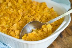 a white dish filled with cornflakes and a spoon