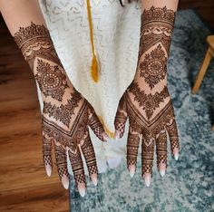 a woman's hands decorated with hennap and tassels on top of her arm