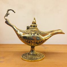 an ornate brass teapot on a wooden table