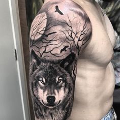 a man's arm with a wolf and tree tattoo on the left side of his body