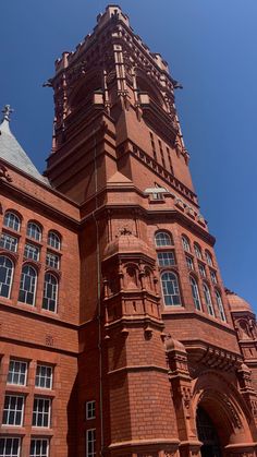 a tall brick building with a clock on it's side and a sky background