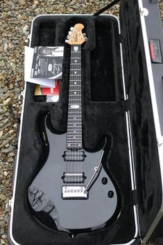 an electric guitar in its case on the ground