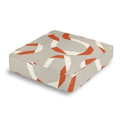 an orange and white square cushion on a white background