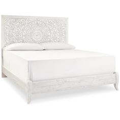 a white bed with an intricate design on the headboard and foot board, made out of wood