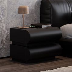 a bed with a black leather headboard and night stand