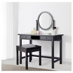 a vanity table with two stools and a round mirror