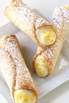 two lemon meringue pies on a plate with the words cannoli