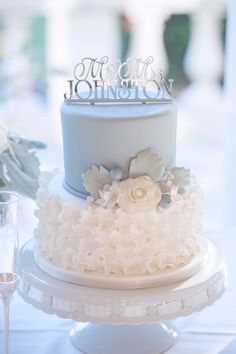 a three tiered wedding cake with flowers on top