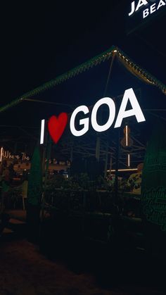 i love goa sign lit up at night in front of a building with lights on it