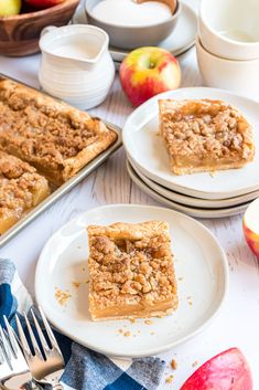 two pieces of apple pie sitting on plates next to an empty plate with one slice missing