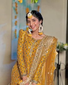 a woman in a yellow outfit with flowers on her head