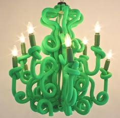 a green chandelier with lit candles in it