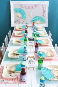 a table set up for a birthday party with paper fans and condiments on it