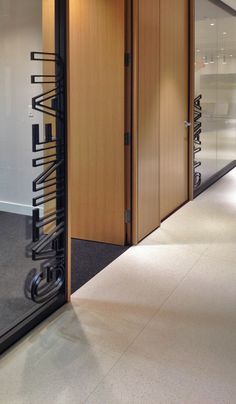 an office hallway with wooden doors and glass dividers