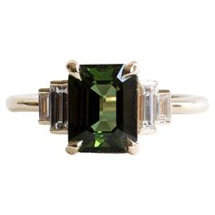 an emerald and diamond ring with three baguets