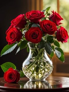 a vase filled with red roses on top of a table