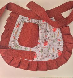 a red and white bag sitting on top of a table next to a pair of scissors