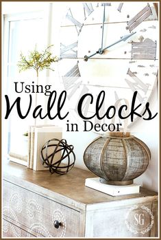 a clock sitting on top of a dresser next to a vase with flowers in it