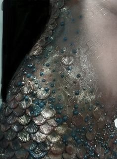 the back of a woman's dress made out of shells and pearls is shown in black and white