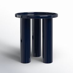 two black round tables sitting next to each other on a white surface and one is turned upside down